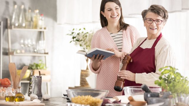 77351596 – happy women standing and cooking in modern kitchen